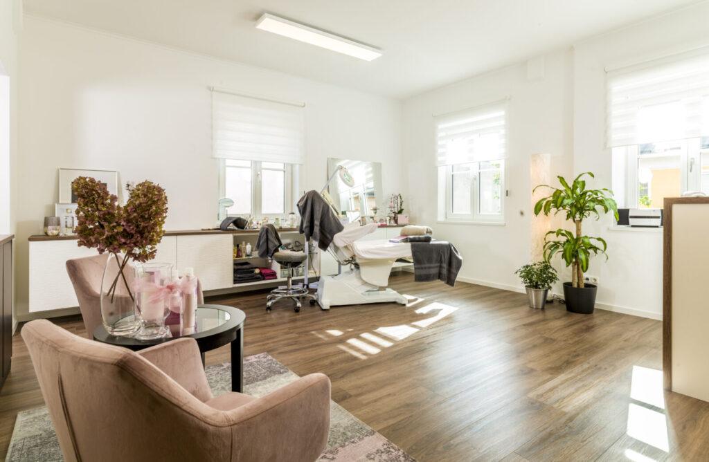 Heller und einladender Raum eines Beauty Salons mit eleganter Einrichtung und pflanzlicher Dekoration.